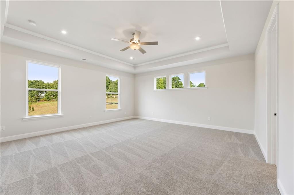 6944 Melody Ridge Road Buford, GA 30518 - Photo 12 of 24 an empty room with windows and ceiling fan