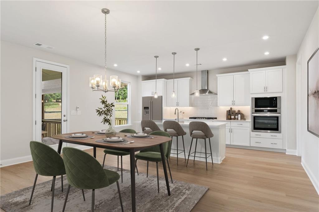 6944 Melody Ridge Road Buford, GA 30518 - Photo 5 of 24 a kitchen with stainless steel appliances kitchen island granite countertop a dining table chairs and a refrigerator