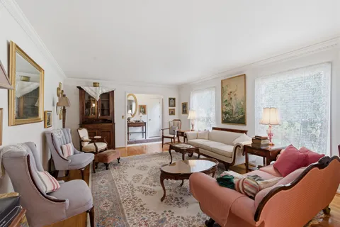 a living room with furniture kitchen view and large windows