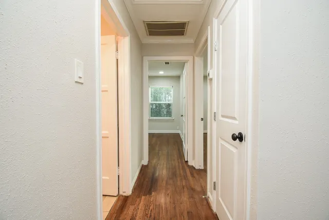 a view of a hallway with wooden floor