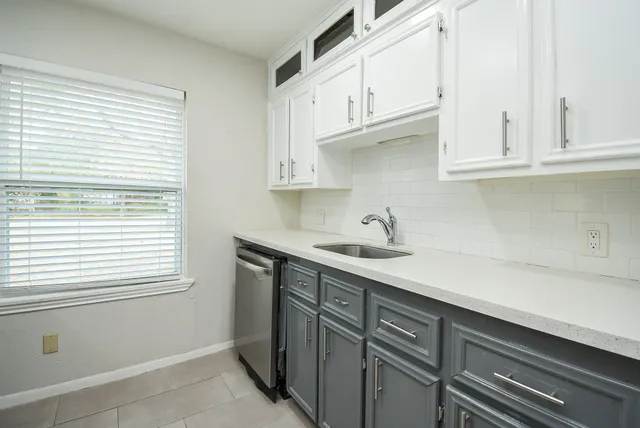 a kitchen with stainless steel appliances granite countertop white cabinets and a sink