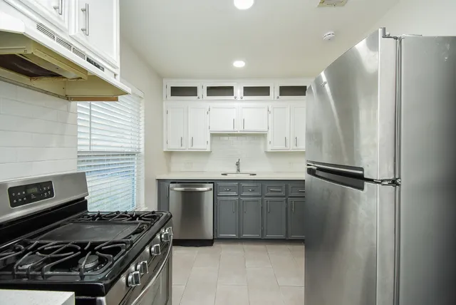 a kitchen with stainless steel appliances granite countertop a refrigerator and a stove