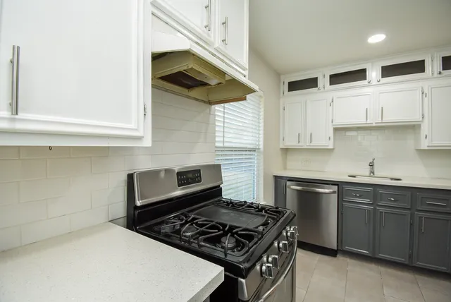 a kitchen with stainless steel appliances a sink and a stove