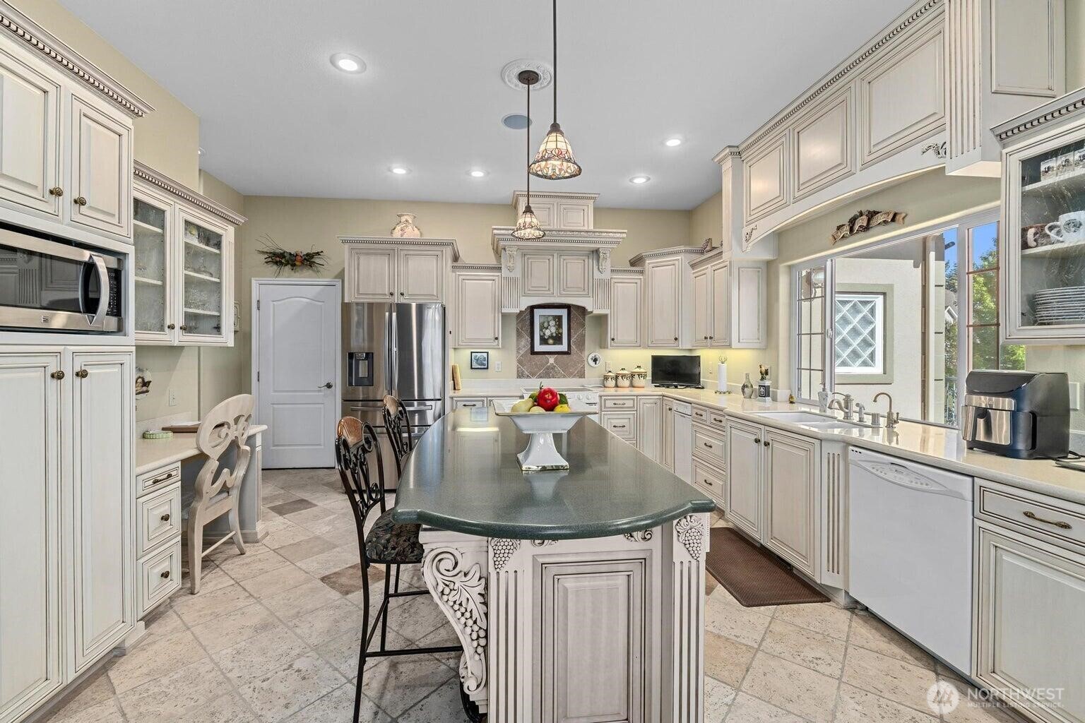 1650 East Fairway Loop Road Colville, WA 99114 - Photo 8 of 30 a kitchen with kitchen island granite countertop a table chairs refrigerator and cabinets