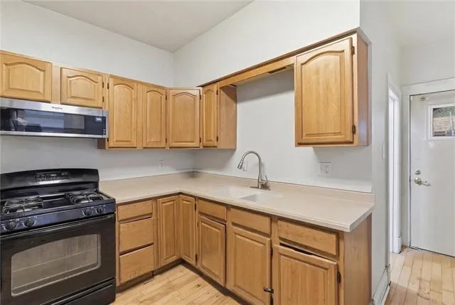 a kitchen with stainless steel appliances granite countertop a sink stove and cabinets