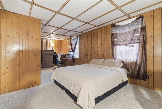 a bedroom with a bed next to a window