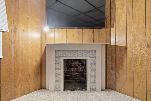 a view of an empty room with a fireplace and a window