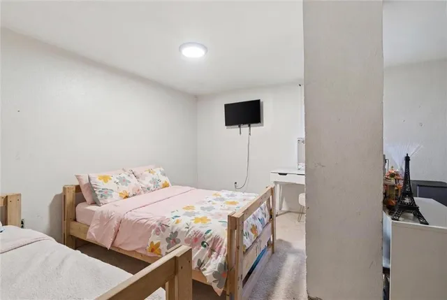 a bedroom with a bed and a flat screen tv