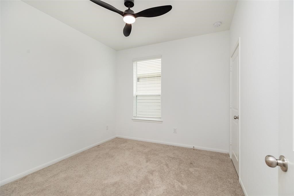 23631 Simmental Road Hockley, TX 77447 - Photo 18 of 22 an empty room with a window and a fan