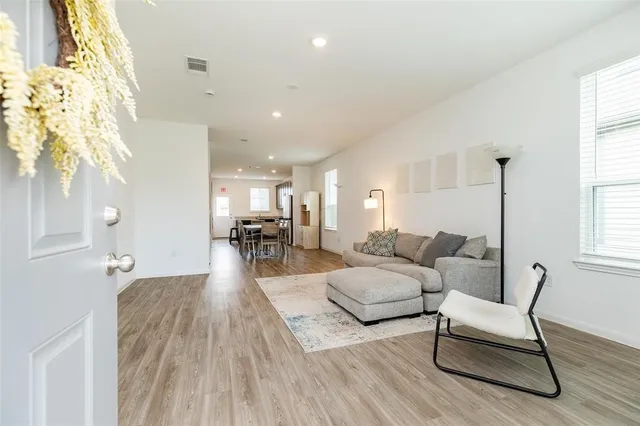 a living room with furniture and a wooden floor