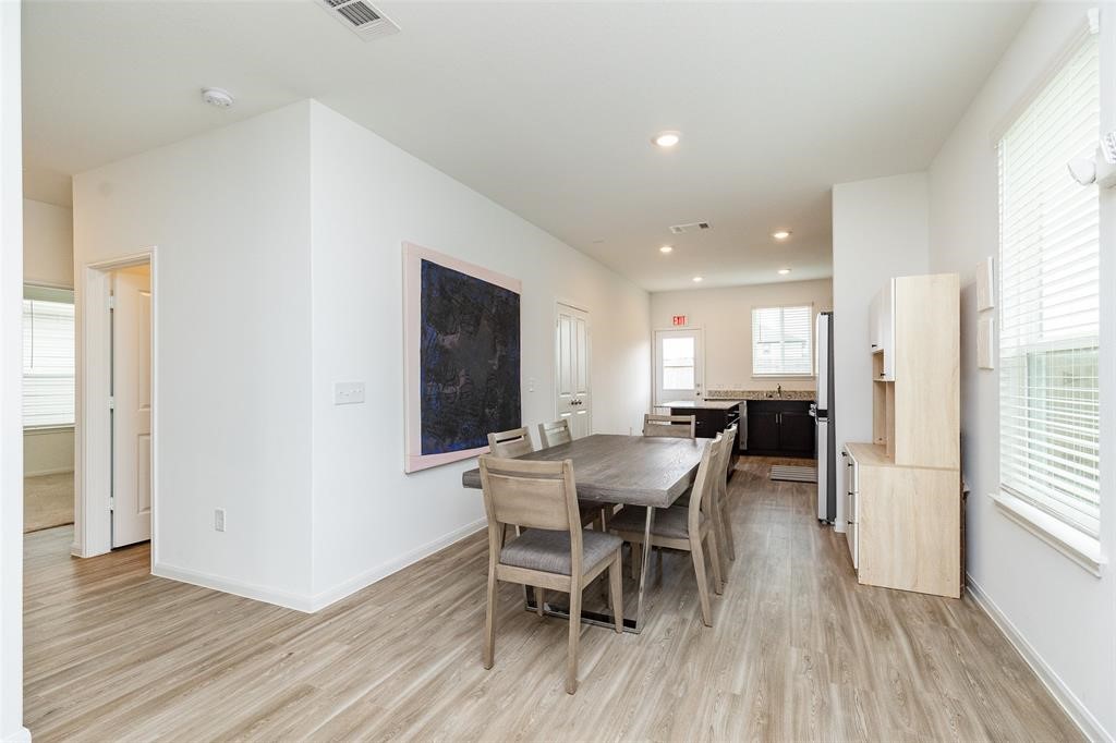 23631 Simmental Road Hockley, TX 77447 - Photo 6 of 22 a view of a dining room with furniture and wooden floor