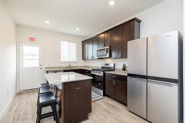 a kitchen with a refrigerator a sink and wooden cabinets