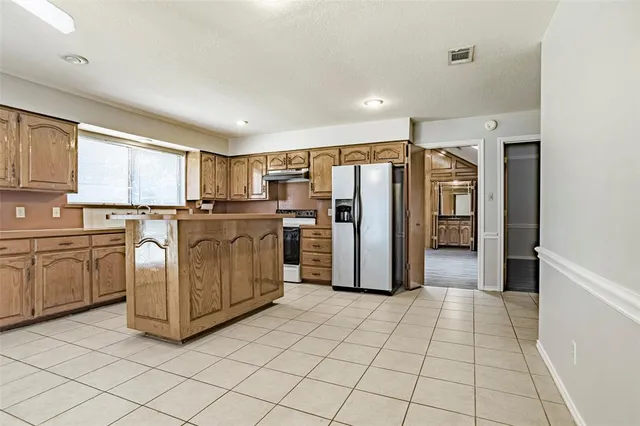 a kitchen with stainless steel appliances a refrigerator sink and cabinets