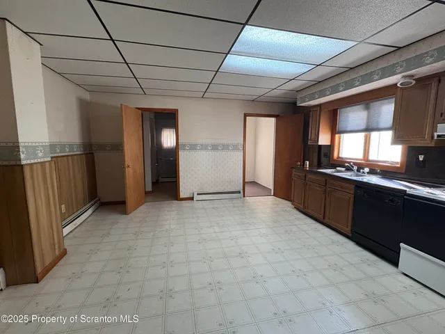 a view of an empty room with a kitchen