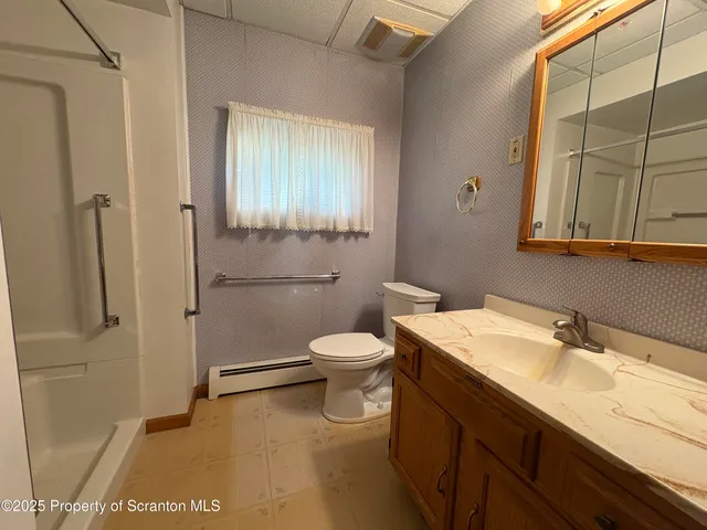 a bathroom with a sink a toilet and shower