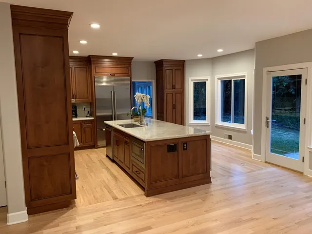 a kitchen with stainless steel appliances granite countertop a refrigerator a sink and a stove