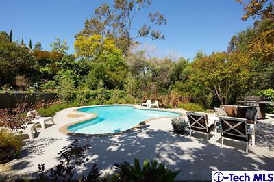 a view of a swimming pool with a yard and sitting area