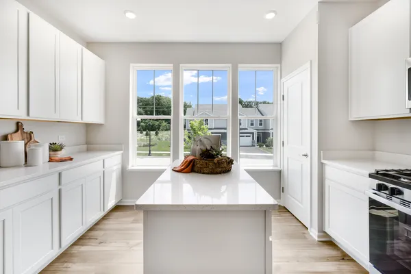 a kitchen with microwave a stove and cabinets