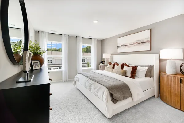 a bedroom with a bed a mirror and a large window