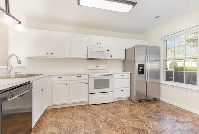 a kitchen with stainless steel appliances white cabinets and wooden floors