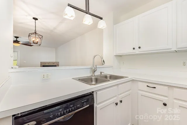 a kitchen with granite countertop white cabinets and white appliances
