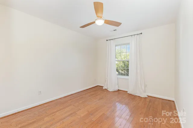 an empty room with a chandelier fan