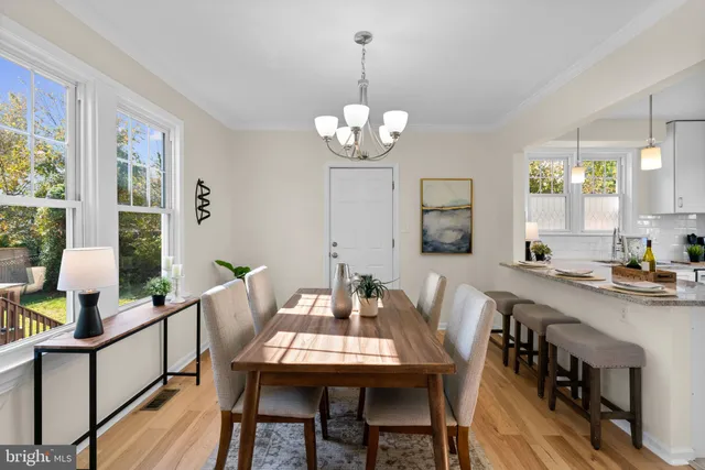 a view of a dining room with furniture a chandelier and wooden floor