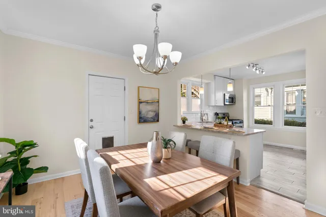 a view of a dining room with furniture a chandelier and wooden floor