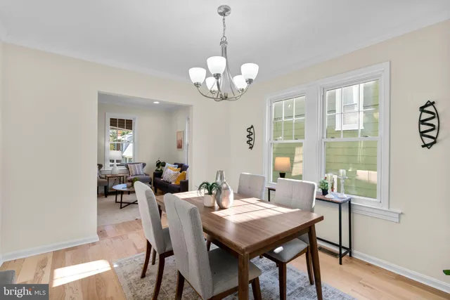 a view of a dining room with furniture a chandelier and wooden floor