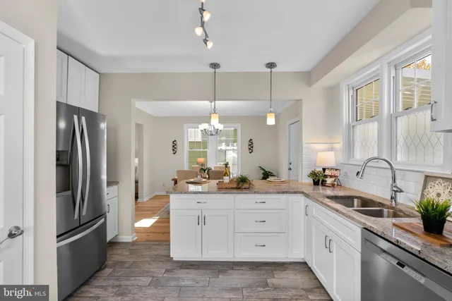 a kitchen with stainless steel appliances a sink cabinets and a refrigerator