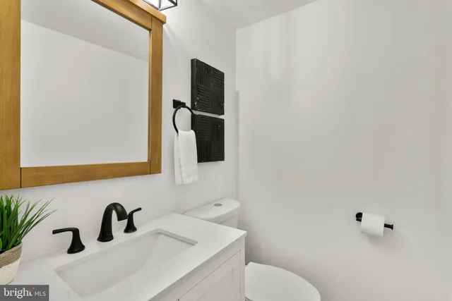 a bathroom with a sink mirror and toilet