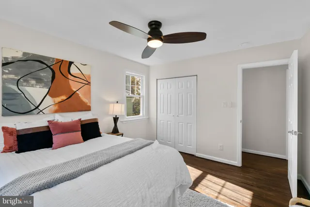 a bedroom with a bed a ceiling fan and a window