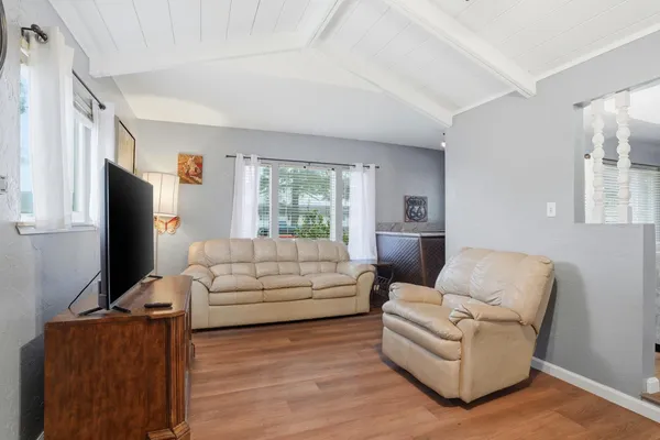 a living room with furniture a flat screen tv and a window