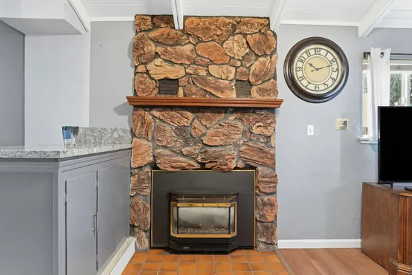 a stone fireplace with a clock on the wall and a clock on top