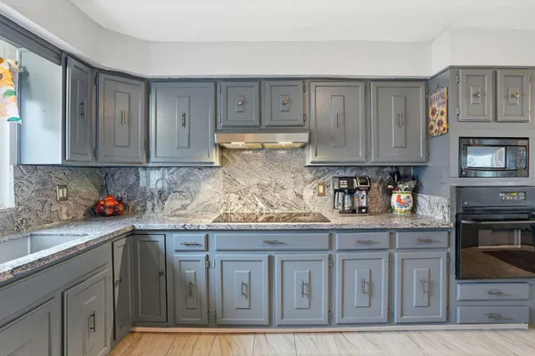 a kitchen with stainless steel appliances granite countertop a stove and cabinets