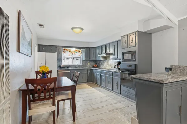 a kitchen with a table chairs and a refrigerator