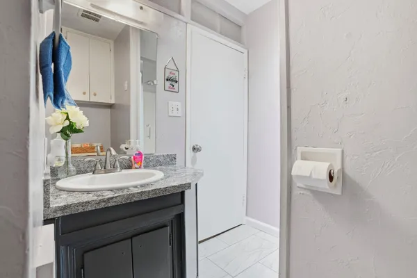 a bathroom with a granite countertop sink and a mirror