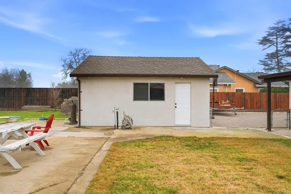 a backyard of a house with table and chairs