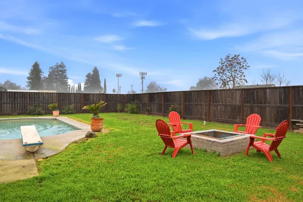 a backyard of a house with table and chairs