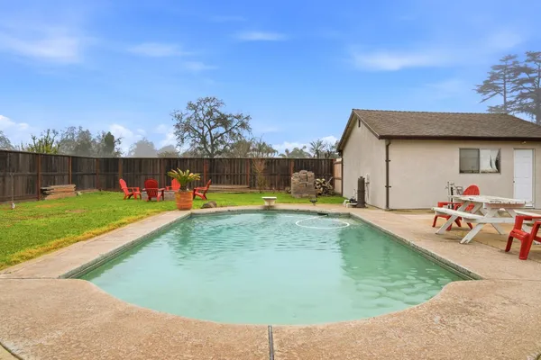 a view of a swimming pool with a yard and sitting area