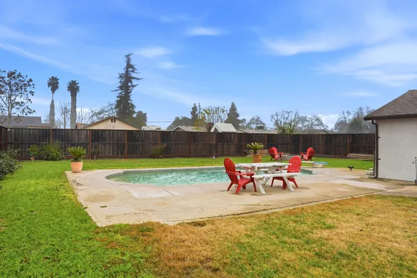 an outdoor sitting area with couch and wooden fence