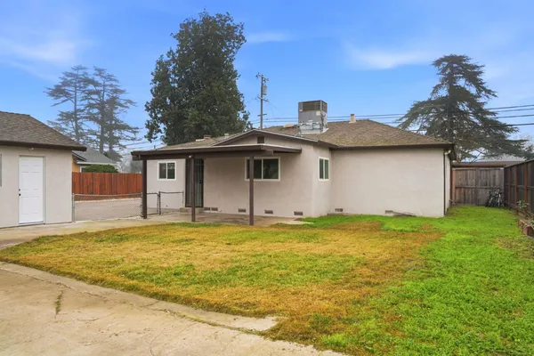 a view of a house with a backyard and a tree
