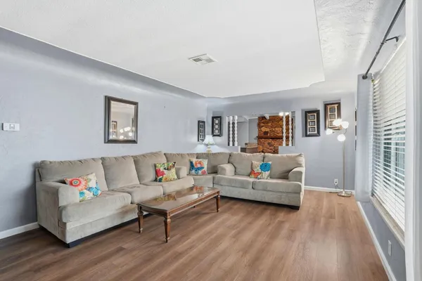 a living room with furniture and a wooden floor