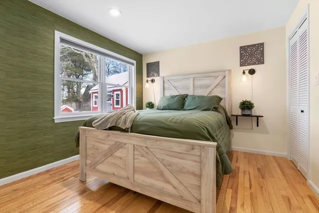 a bedroom with a bed and wooden floor