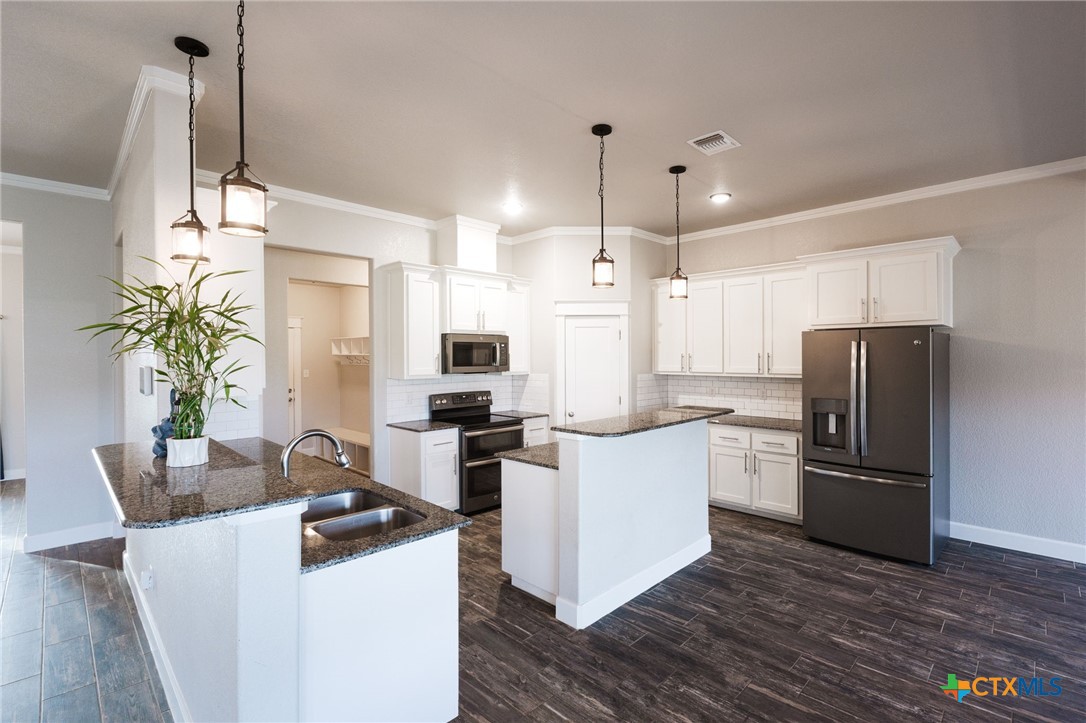 2662 Snow Road Kempner, TX 76539 - Photo 8 of 28 a kitchen with stainless steel appliances a refrigerator a sink a stove a dining table and chairs