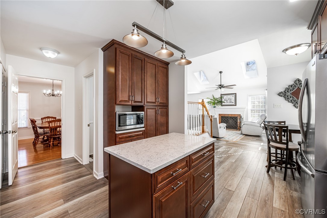 4600 Cedar Cliff Road Chester, VA 23831 - Photo 12 of 37 a kitchen with granite countertop a refrigerator a stove top oven a dining table and chairs with wooden floor