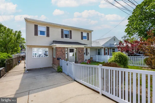 a view of a house with a small yard and wooden fence
