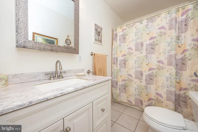 a bathroom with a granite countertop sink a toilet and a mirror