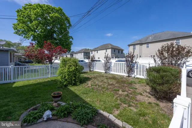 a view of a house with a yard and potted plants