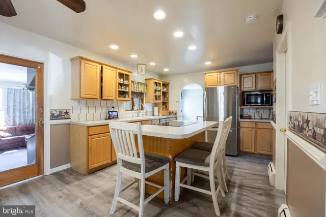a kitchen with stainless steel appliances kitchen island granite countertop a sink and cabinets